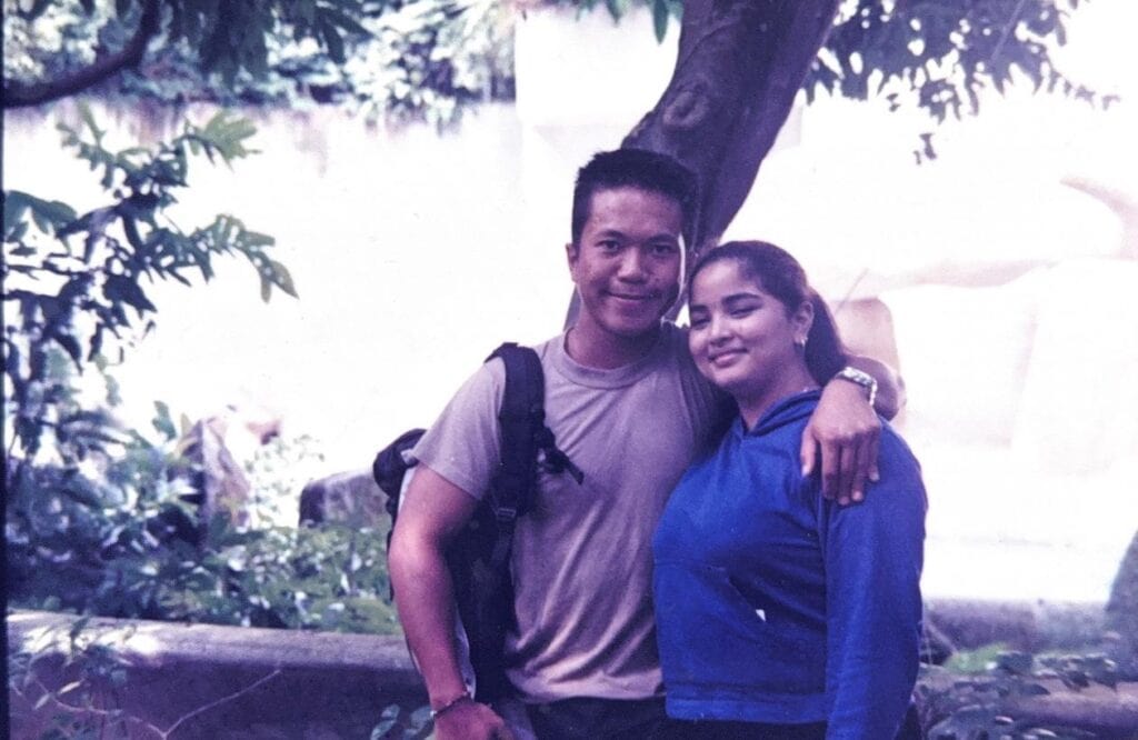 Old photograph of Mr Wong with his arm across the shoulders of Mdm Nooraini at the park
