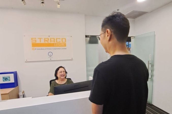 Building an Inclusive Workforce: Singapore Flyer’s Commitment to Diversity 1 Mdm Yati behind the reception counter speaking happily with a colleague.