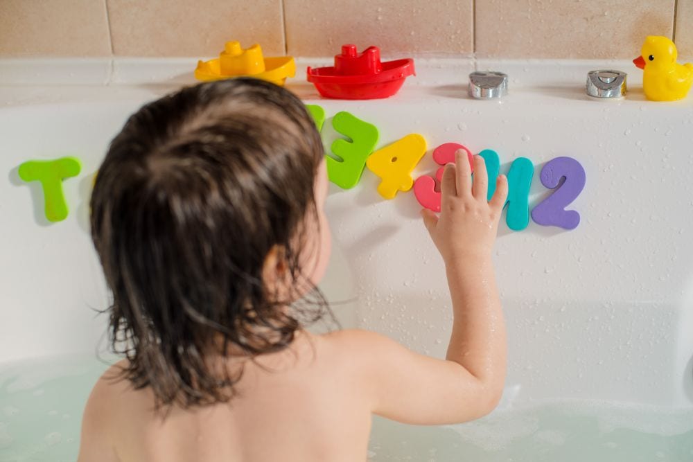 Turning Shower Time into a Positive Learning Experience for Children 2 Child in shower playing with foam letters.