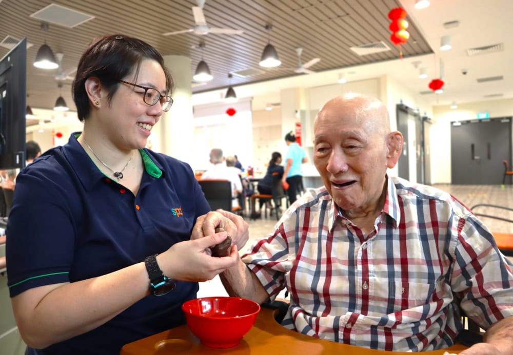 Supporting seniors with heart, connection and purpose 1 S P D occupational therapist and a senior engaged in table top activities.