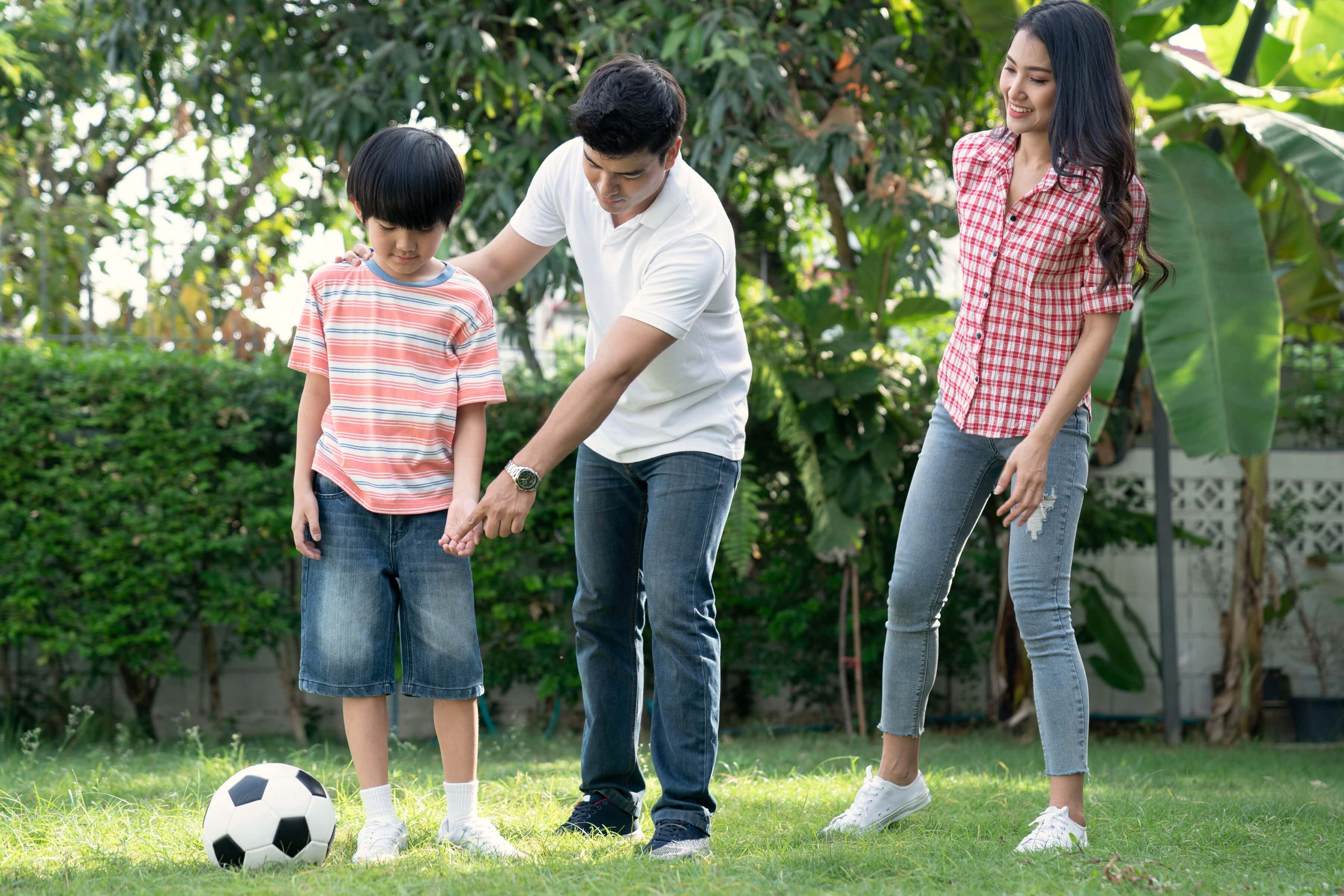 Experiencing Language - A Multisensory Approach to Language Learning 2 A father gesturing for his boy to kick a boy as the mother looks on
