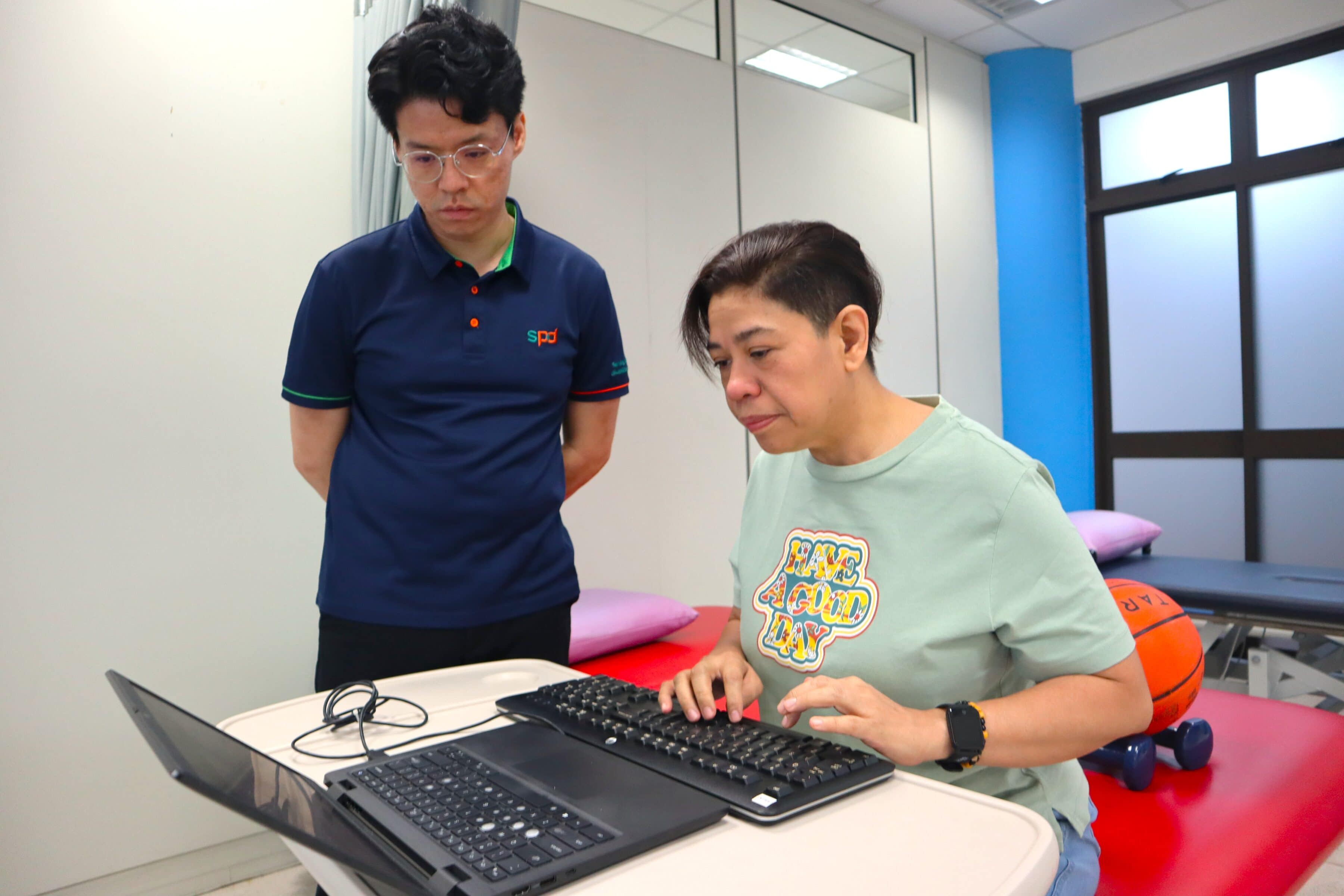 Power of Care – Celebrating Every Step Forward 1 Chris looks on as a client uses a laptop