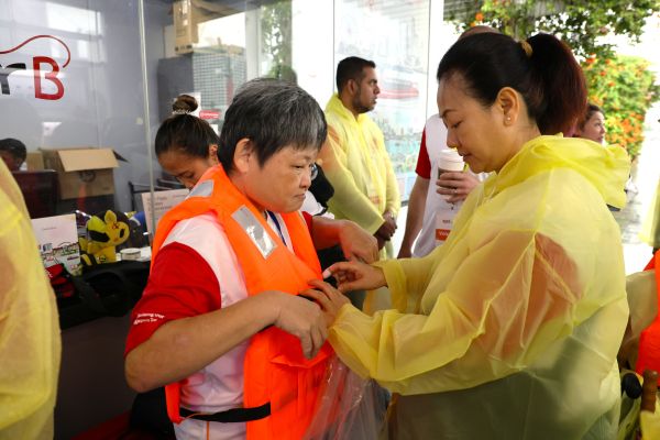 Behind the scenes: Bringing an inclusive cruise ride to life at SPD Ability Walk 2025 5 A volunteer helping an S P D client with her life vest before the cruise ride.