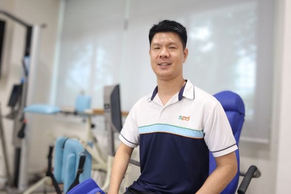 Power of Care – Holistic Care Through Collaboration 3 Winson seated on an exercise machine