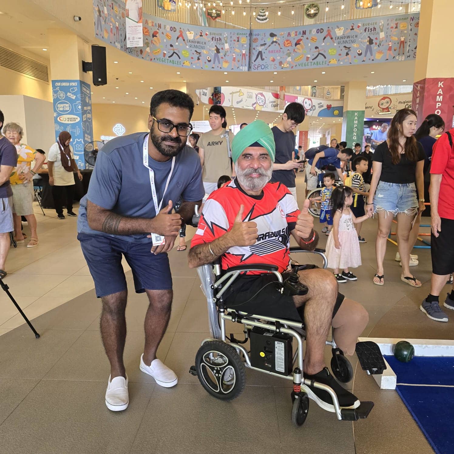 Strength in Community: Living with vision and hearing loss, youth volunteer supports others through boccia 4 Vinid with a wheelchair user at the E S H Tampines Eat Play Live community event.