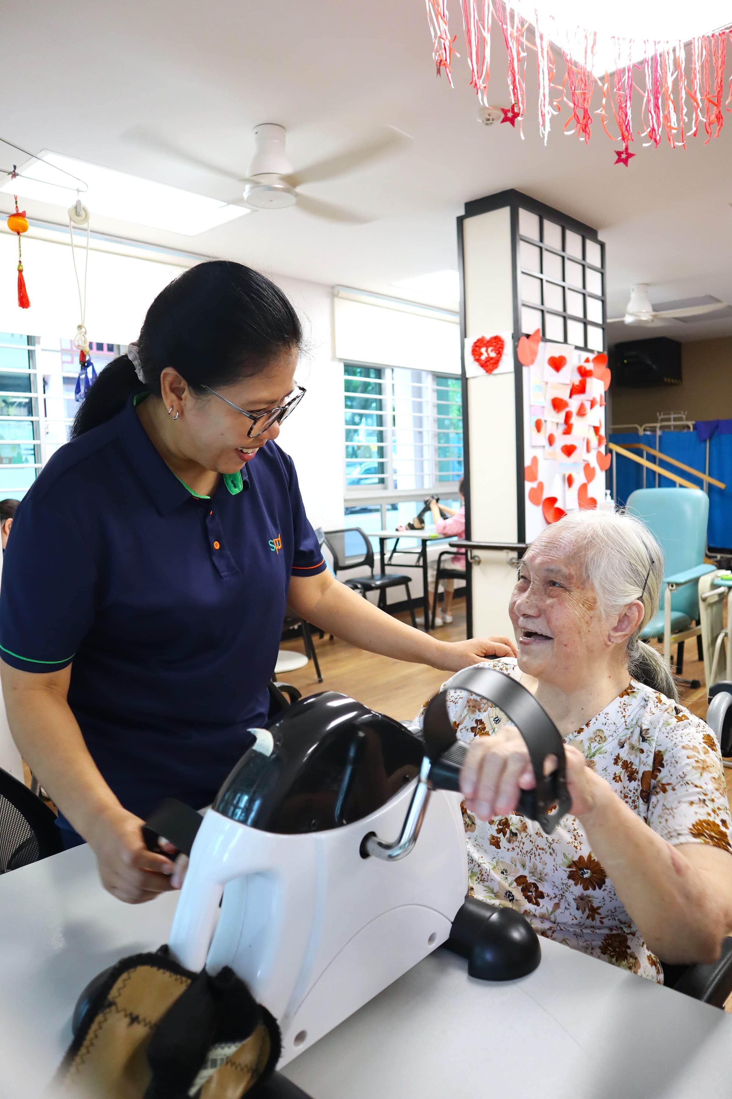 Celebrating Service Excellence at SPD: Honouring our Singapore Health Quality Service Awards 2026 recipients 3 Mas Ayu guiding a senior client who is on the hand-cycle