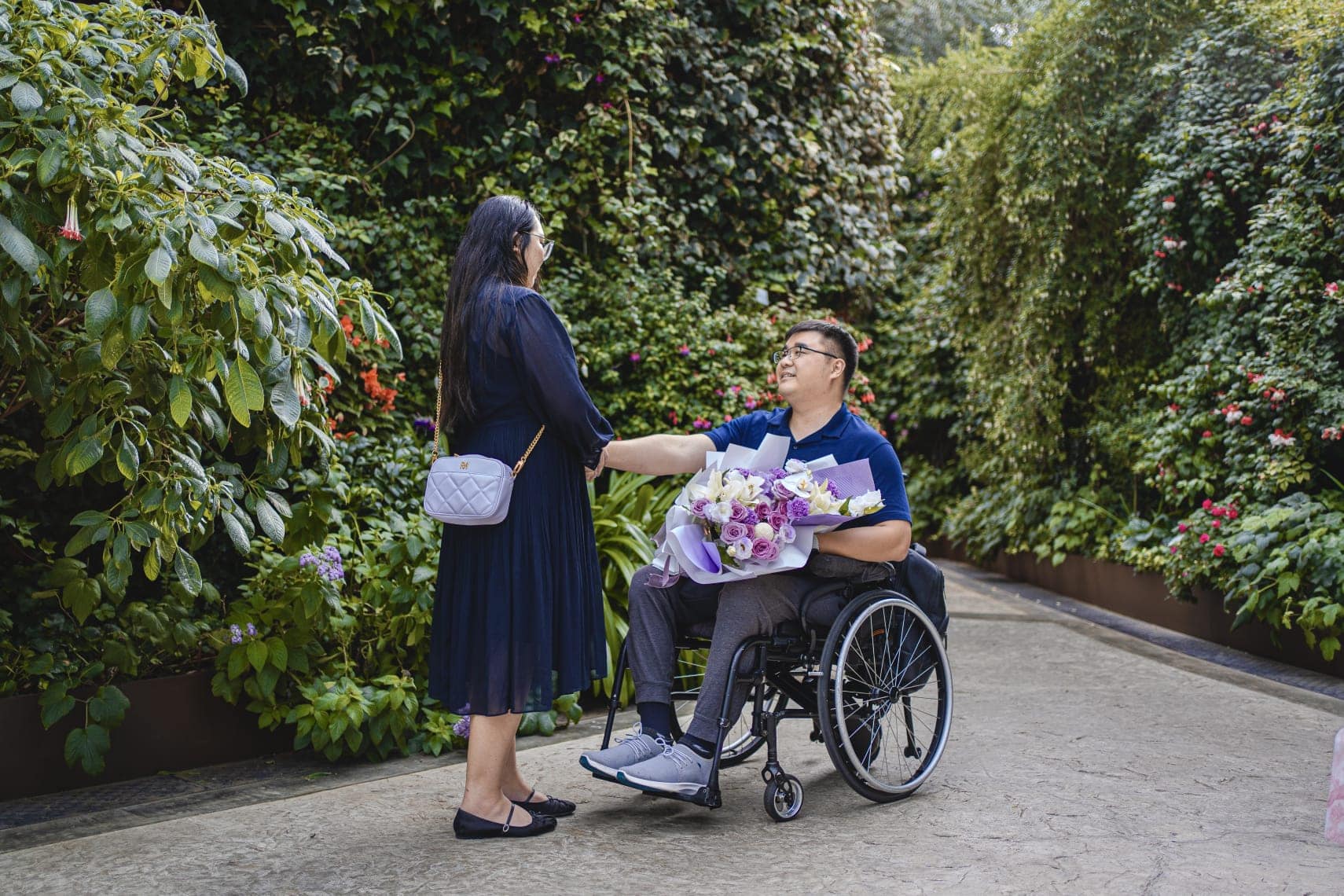 Kishon holding a bouquet of flower and speaking to Kelly at the garden.