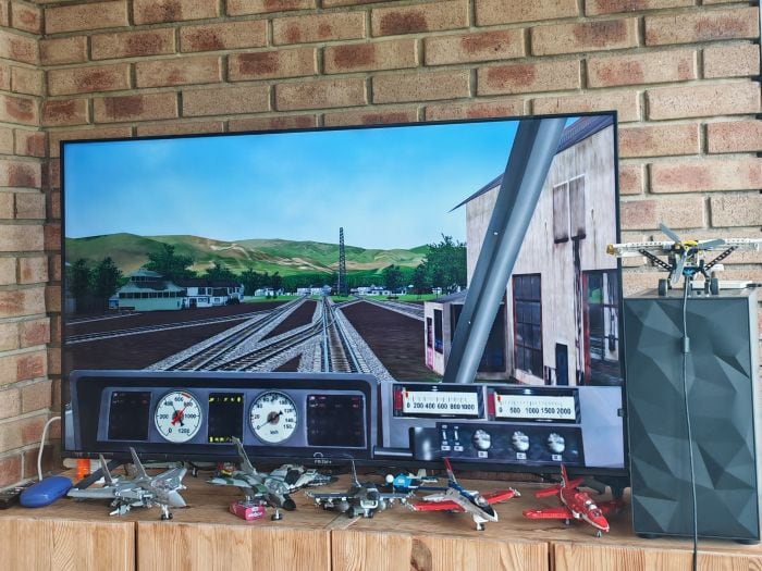A television showing a game which is a first person view of a locomotive operator.