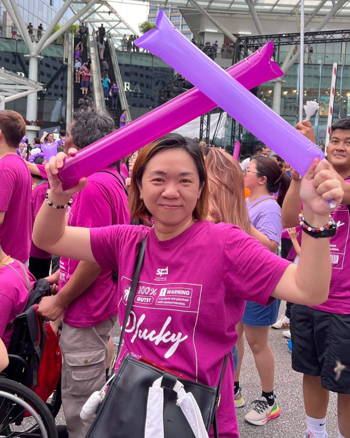 Where Purpose Found Me: Alexis' journey back to SPD 4 Alexis in the SPD contingent holding up 2 inflatable clappers at the Purple Parade