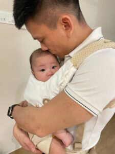 Showing Up with Heart: Occupational therapist Bradley Lam on fatherhood and caregiving 1 Bradley hugging baby daughter in his arms in baby carrier