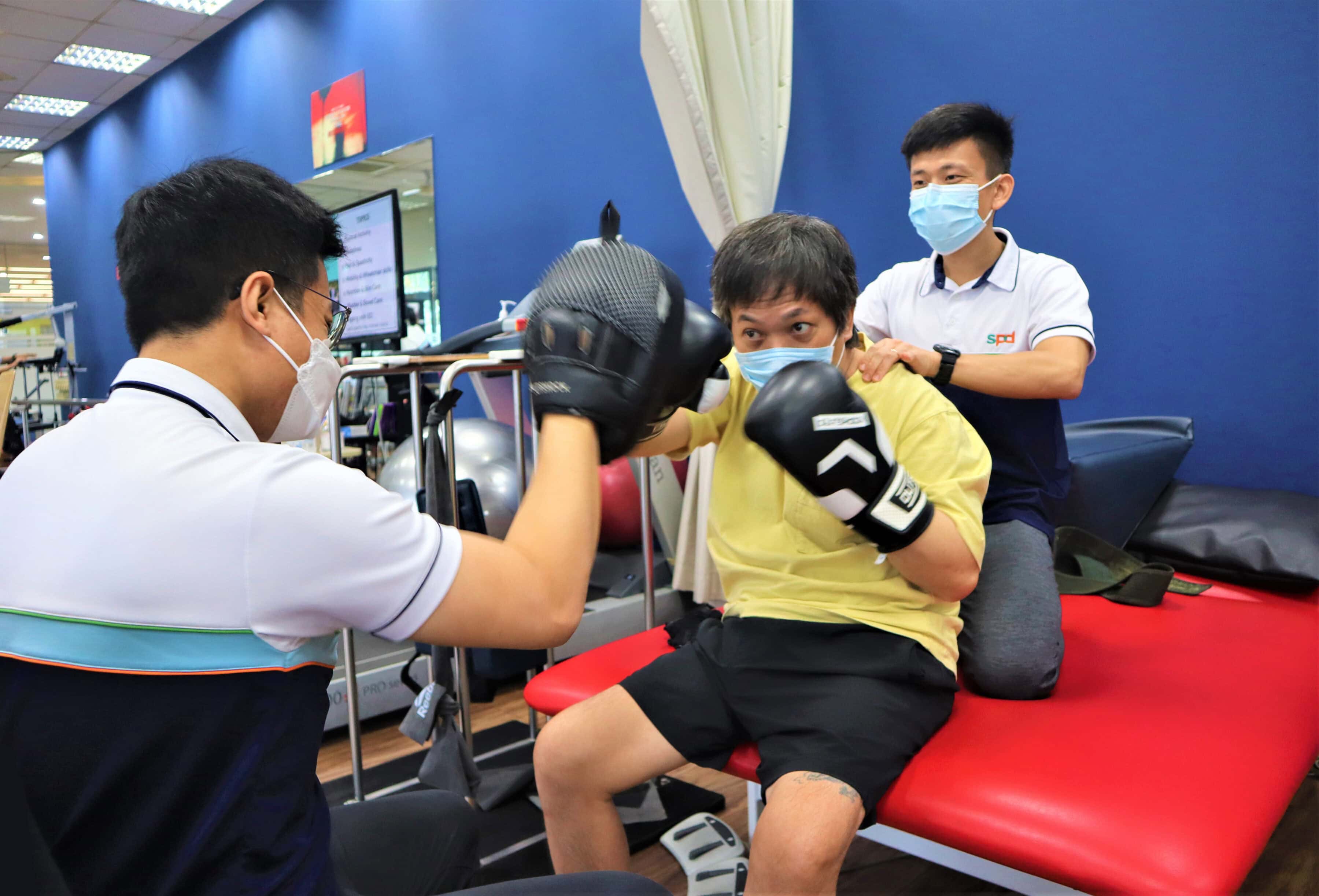 Showing Up with Heart: Occupational therapist Bradley Lam on fatherhood and caregiving 3 Bradley and a fellow therapist with a client in boxing exercise