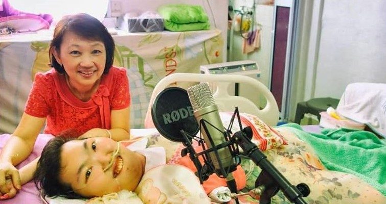 Vivian lying on her bed with her mum beside her