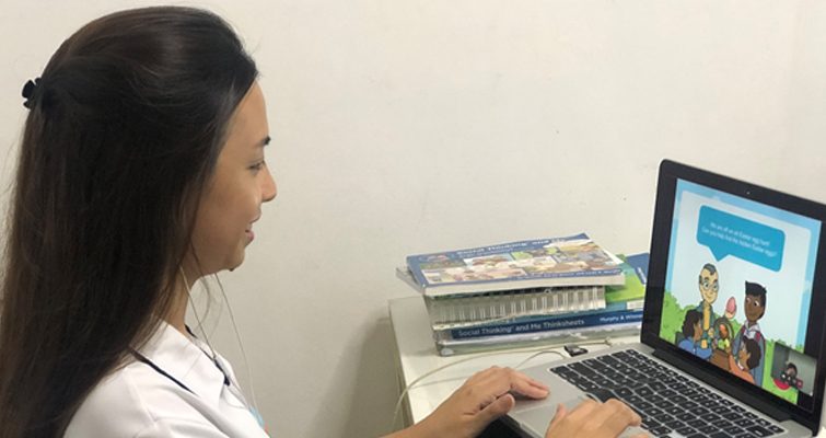 A therapist using customised PowerPoint slides to engage the child during an ongoing telepractice session