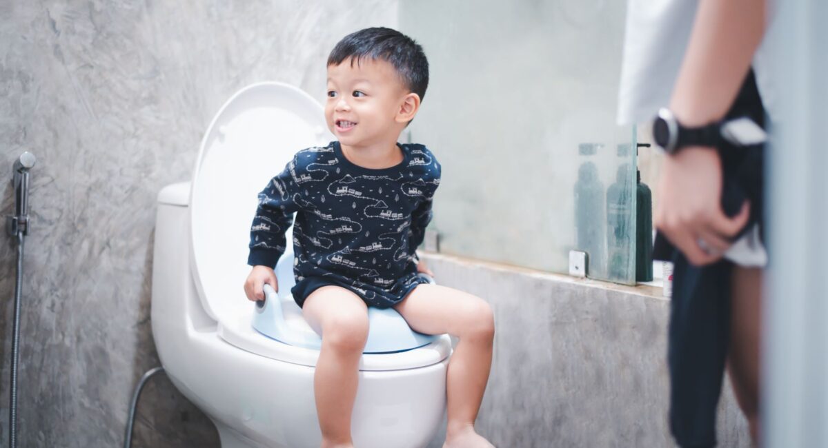 Boy sitting on toilet bowl