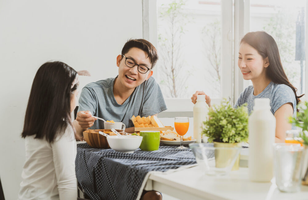 Man, woman and girl having a meal at a table