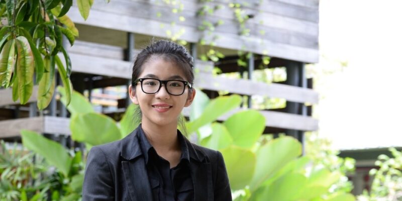 Zi Lin standing in front of lush greenery