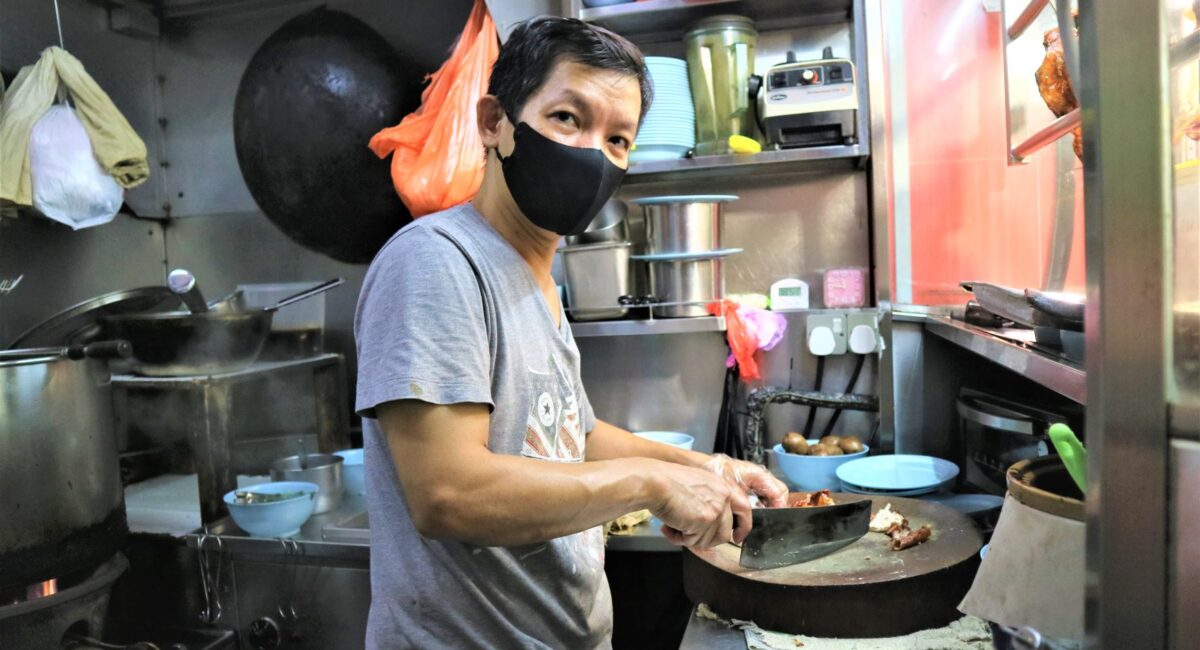 Mr Chan chopping chicken at his stall