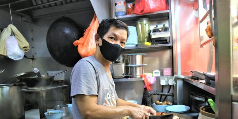 Mr Chan chopping chicken at his stall