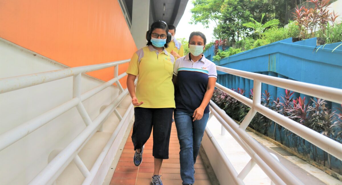 S P D training officer walking with a Day Activity Centre client