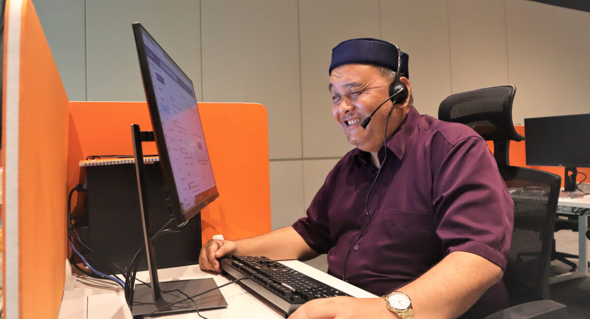 Mr Mohaimin, who has vision loss, looks intently at the computer screen