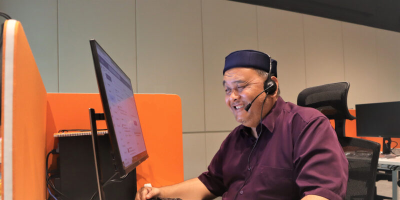 Mr Mohaimin, who has vision loss, looks intently at the computer screen