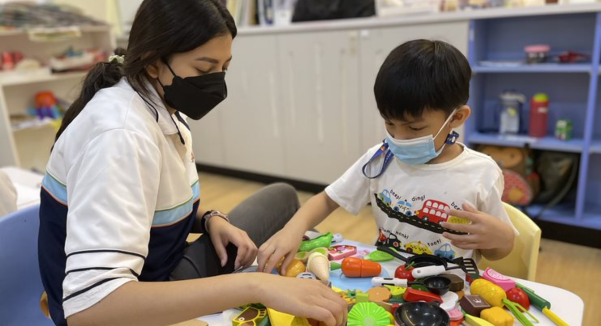 A S P D teacher engaging a child in play activities