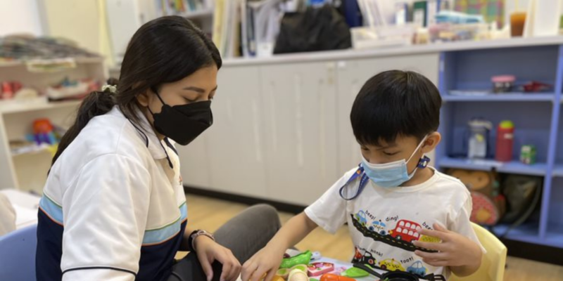 A S P D teacher engaging a child in play activities