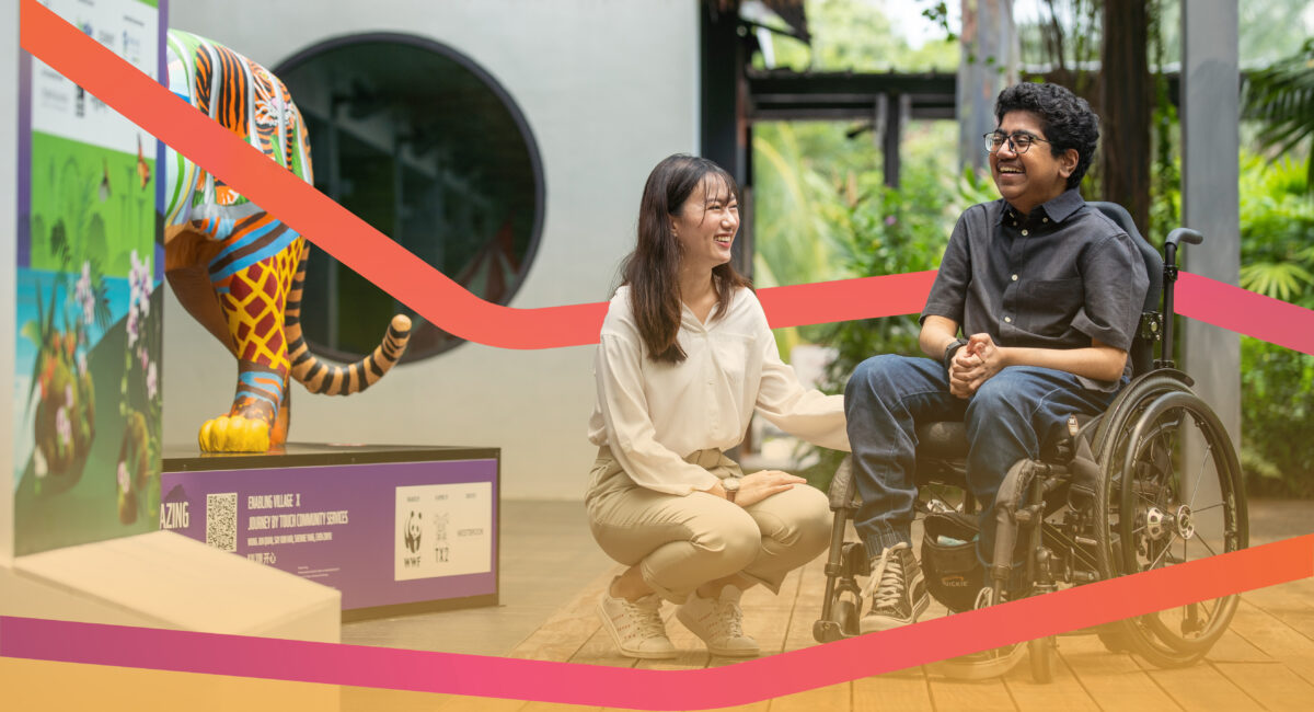 A volunteer positioning herself beside a wheelchair user, both smiling