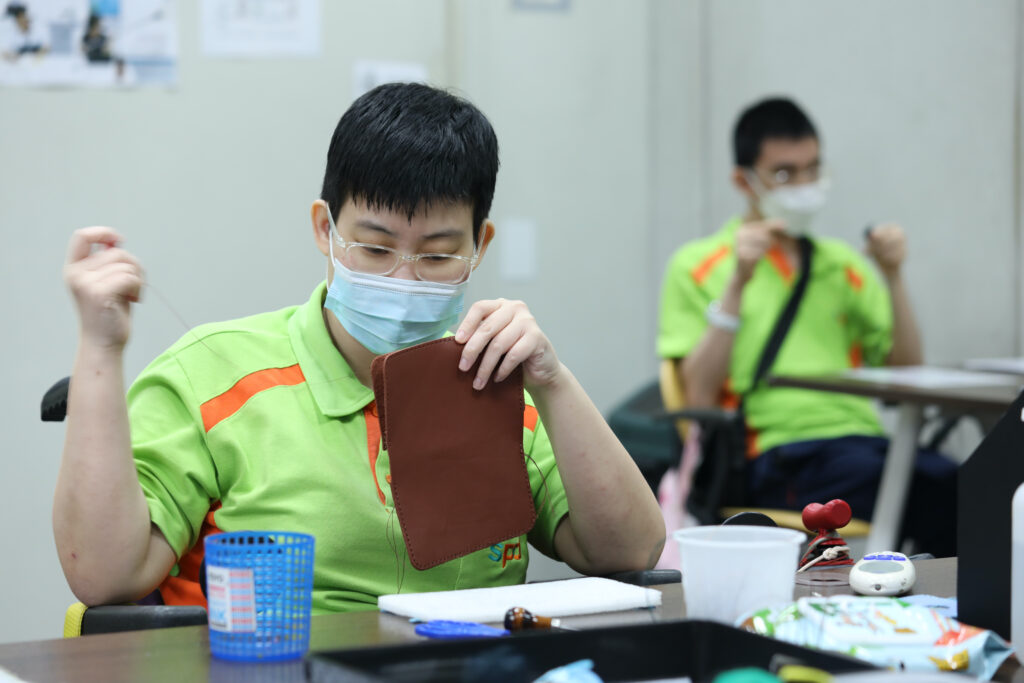 A S P D artisan sewing a leather product