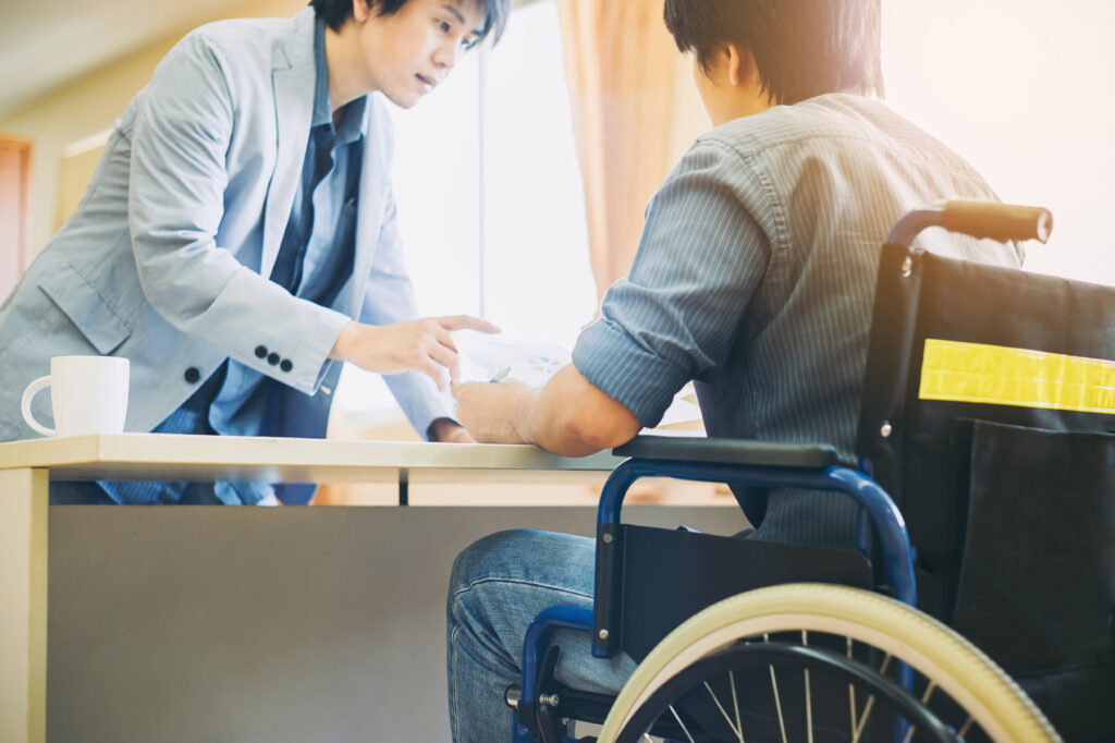 A wheelchair user speaking with a man in an office