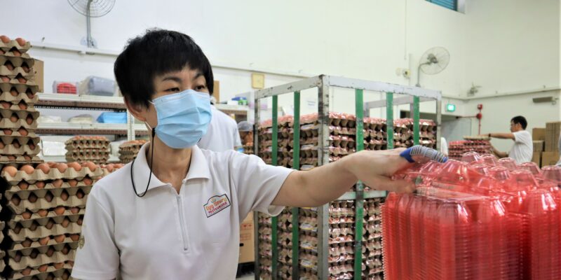 A woman with disability labelling egg cartons