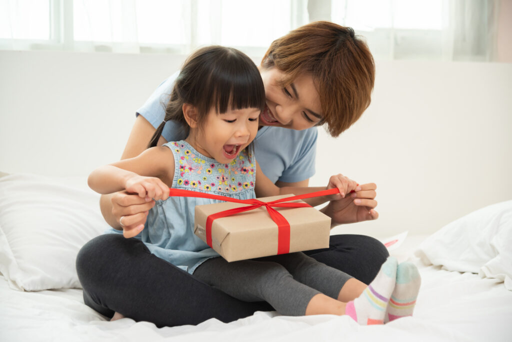 A mother opening a gift with her daughter