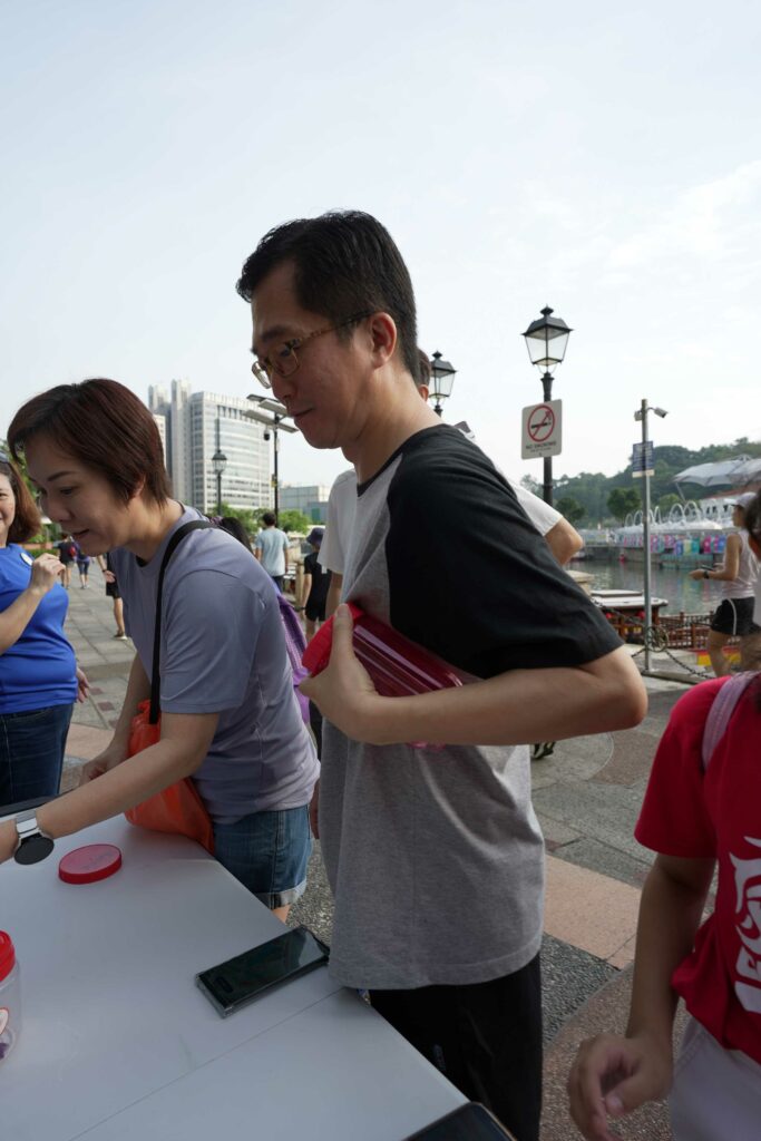 A participant taking part in a disability simulation activity by opening a container and retrieving its content using one hand.