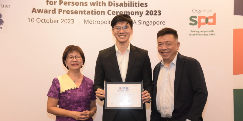 Bjorn holding his scholarship, standing between Ms Denise Phua and Mr Kenneth Choo