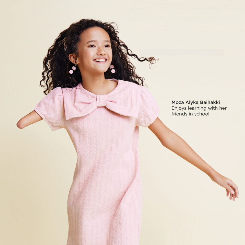 Moza in pink dress smiling