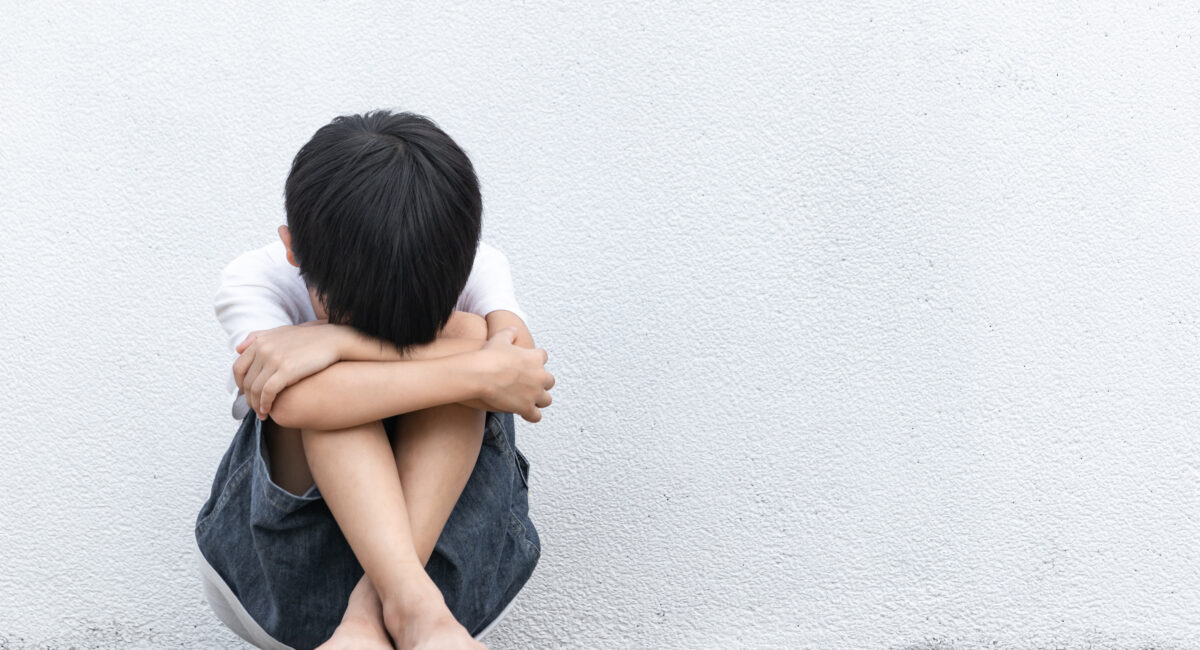 A boy sitting on the ground crying