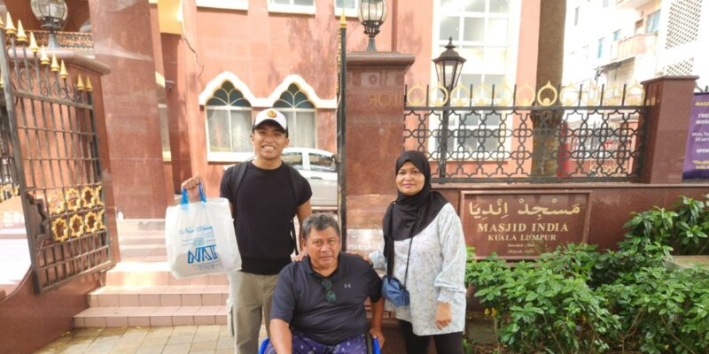 Mr Suhaimi seated in his wheelchair, flanked by his wife Mdm Rahmah Binte Yatin and their eldest son Sufian