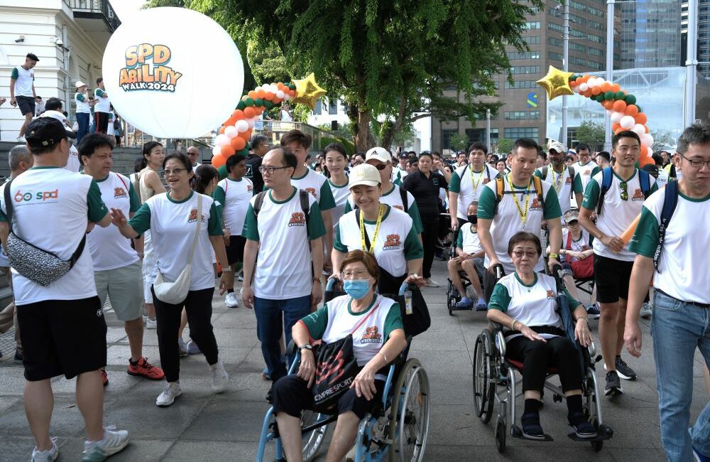 SPD Ability Walk 2024 participants moving off after the flag off, including 2 wheelchair users