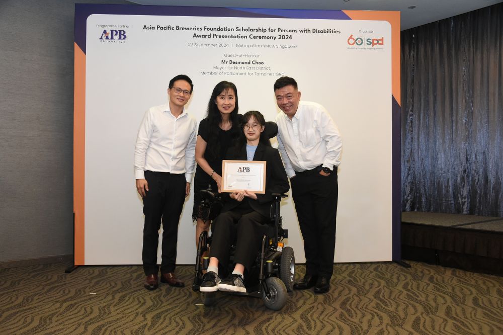 Raphella and her mother receive the scholarship certificate from Guest-of-Honour Mr Desmond Choo, Mayor of North East District, as well as Mr Kenneth Choo, Chairman, Board of Trustees. Asia Pacific Breweries Foundation and Managing Director, HEINEKEN Asia Pacific