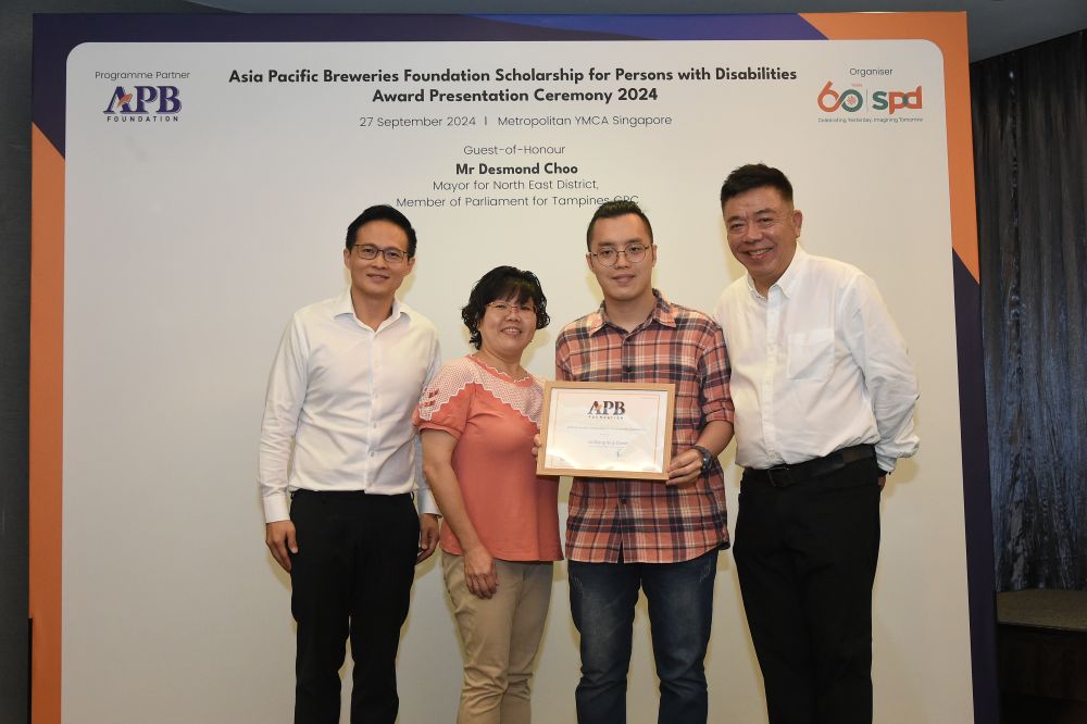 Daniel and his mother at the APB Foundation Scholarship Award Presentation Ceremony 2024 with Guest-of-Honour Mr Desmond Choo, Mayor of North East District, and Mr Kenneth Choo Asia Pacific Breweries Foundation and Managing Director, HEINEKEN Asia Pacific