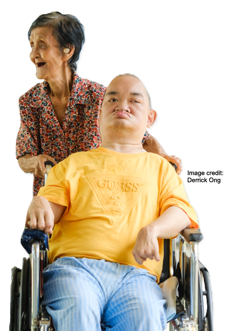 Elderly woman pushes along her adult son with disabilities in his wheelchair