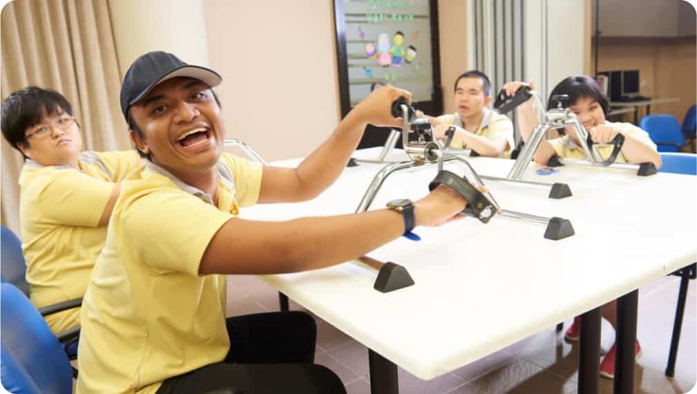 4 3 S P D Day Activity Centre clients using hand exercising equipment and smiling