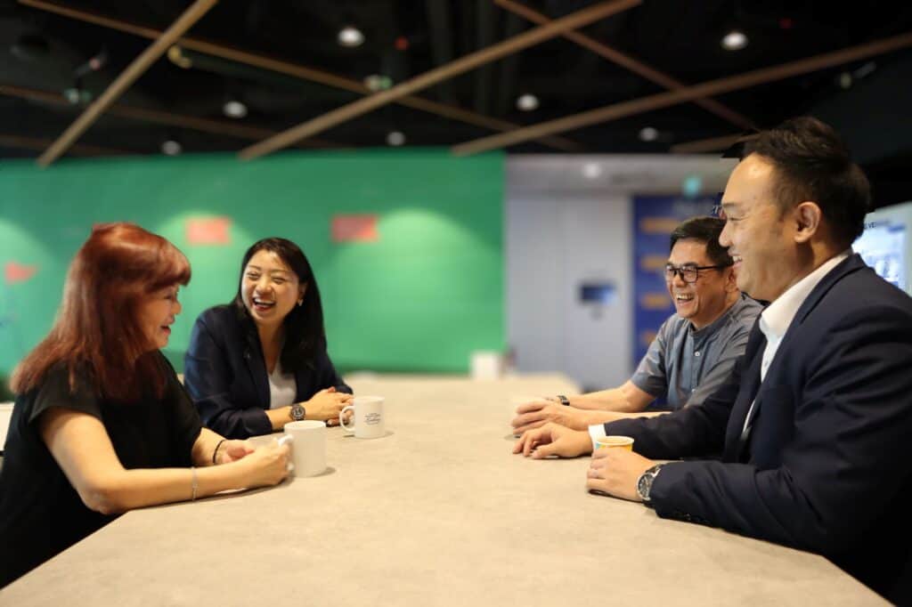 Mr Chong in a lively discussion with a colleague, and his superiors.