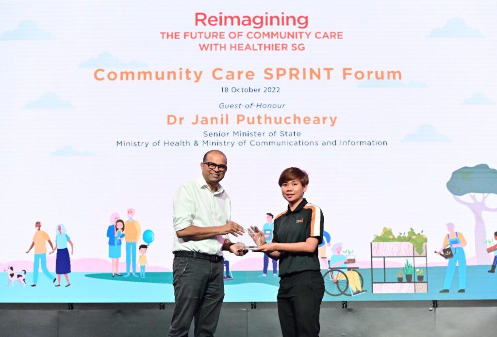 Senior D A C officer Shahidah receiving the award from Dr Janil Puthucheary