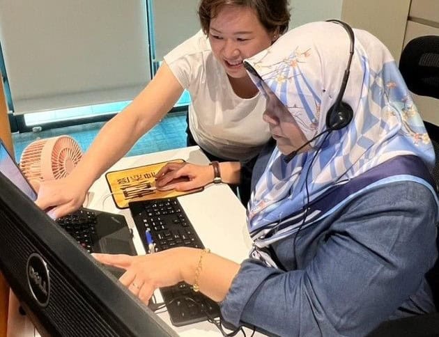 A lady coaching her colleague on the contact centre's operations