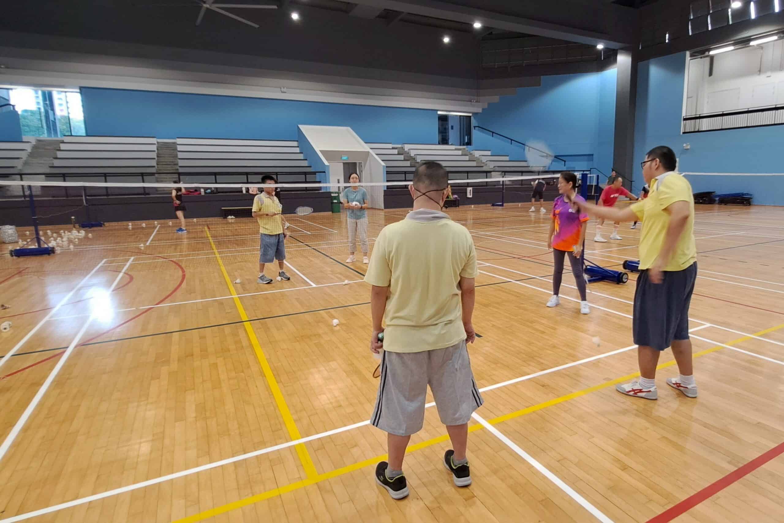 D W W clients playing badminton against each other as a Team Nila volunteer looks on