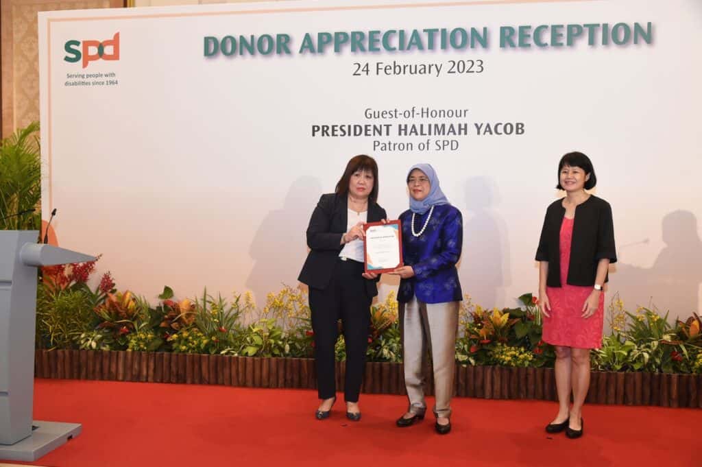 Ms Tan receiving a certificate from President Halimah Yacob