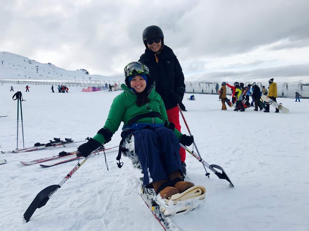 Jean and her husband trying out adaptive skiing