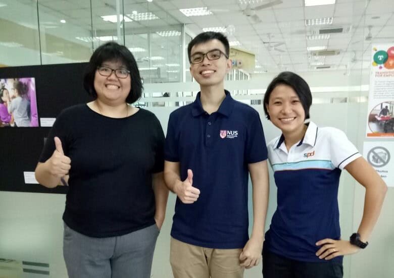 A man and two ladies standing and posing for the camera