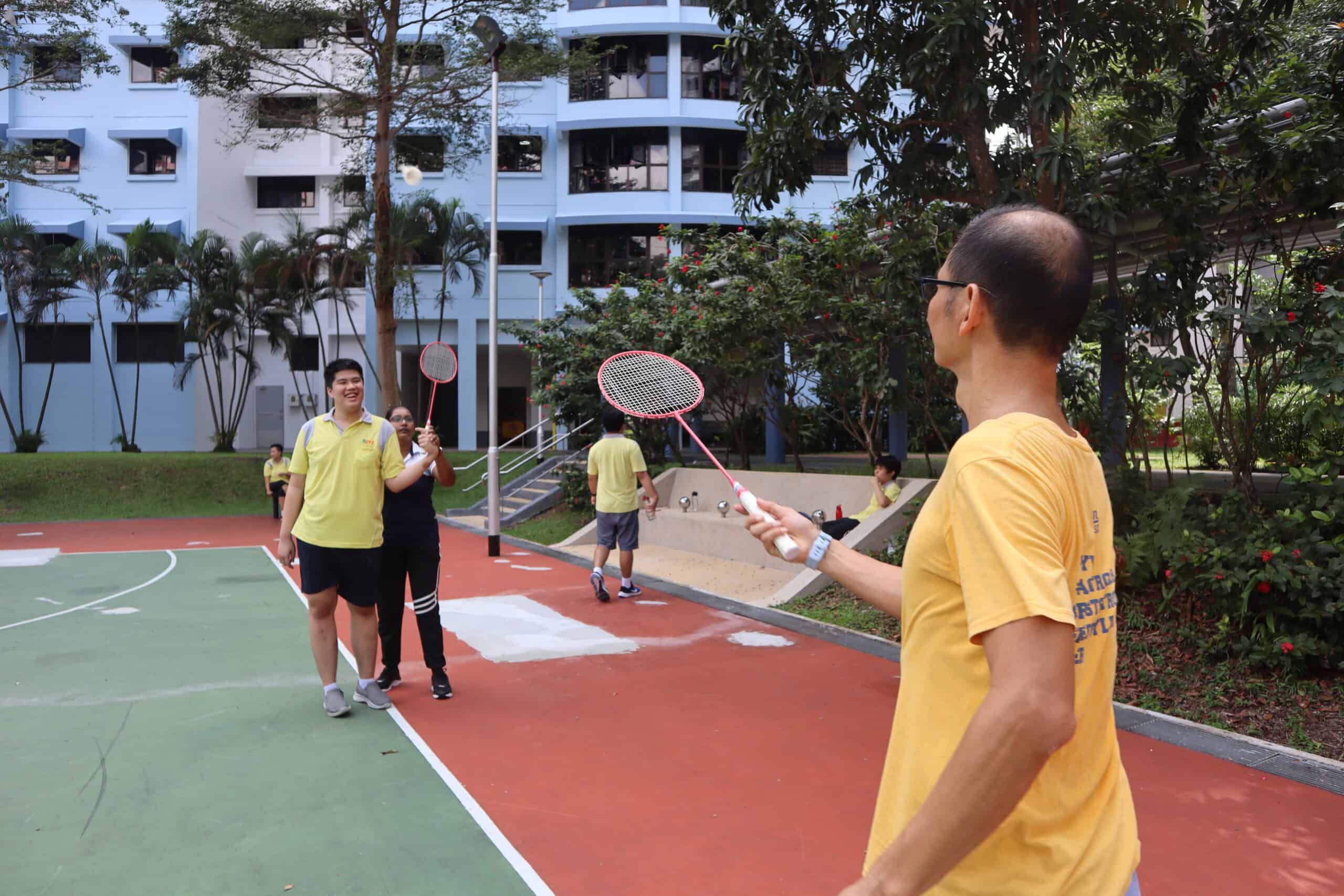 Hong Yun playing badminton with the help of a training officer